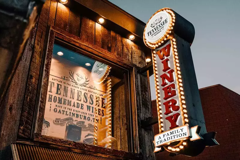 View of the outside of Tennessee Homemade Wines in downtown Gatlinburg at night.
