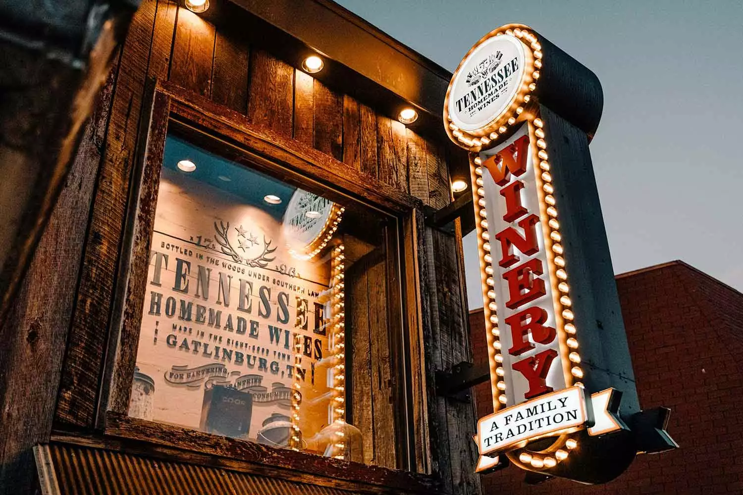 View of the outside of Tennessee Homemade Wines in downtown Gatlinburg at night.
